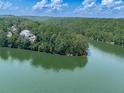 Picturesque waterfront property surrounded by dense greenery and serene waters, showcasing an idyllic lakeside setting at 7560 Island Mill Rd, Acworth, GA 30102