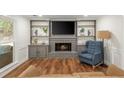 Cozy living room features fireplace with grey brick surround, built-in shelving, and wood flooring at 3375 Rivendell Ct, Roswell, GA 30075