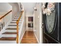 Inviting entryway with hardwood floors and staircase, leading to a glimpse of the adjacent kitchen at 5086 N Woodbridge Trl, Stone Mountain, GA 30088