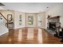 Bright living room with gleaming hardwood floors, bay windows, and a stone fireplace as its focal point at 5086 N Woodbridge Trl, Stone Mountain, GA 30088