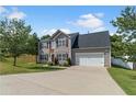 Inviting home with gray siding, dark shutters, a two-car garage, and a spacious driveway nestled on a lush green lawn at 1644 Royal Ives Dr, Lawrenceville, GA 30045