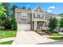 Attractive two-story home featuring a manicured lawn, mature trees, a two-car garage, and a welcoming front porch at 310 Braeden Way, Alpharetta, GA 30009