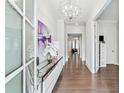 Bright foyer with hardwood floors, modern chandelier, and an open view into the home's living spaces at 310 Braeden Way, Alpharetta, GA 30009