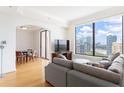 Open living room with hardwood floors, city view and access to dining room at 3445 Stratford Ne Rd # 2409, Atlanta, GA 30326