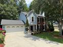 Two-story home with light blue siding, brick accents, mature trees, and a two car garage at 3545 Manchester Dr, Lawrenceville, GA 30044