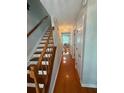 Well-lit hallway featuring hardwood floors, stairs with wooden banisters, and white doors, creating a welcoming entrance at 3545 Manchester Dr, Lawrenceville, GA 30044