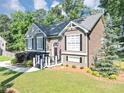 Charming two-story home with well-maintained lawn, colorful flowerbeds, and mature trees at 70 Maplewood Ln, Acworth, GA 30101