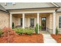 Inviting covered front porch with stone base columns and lush landscaping at 174 Vandiver Ct, Acworth, GA 30101
