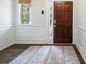 Inviting foyer featuring a dark wood door, decorative rug, and classic wainscoting at 4554 Grenadine Cir, Acworth, GA 30101