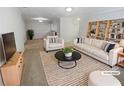 Bright living room featuring a modern couch, chairs, and bookshelf at 501 Vicksburg Pl, Atlanta, GA 30350