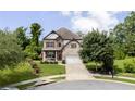 Beautiful two-story home with a well-maintained lawn, attached two-car garage, and traditional brick and stone facade at 521 Andes Ln, Canton, GA 30114