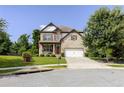 Inviting two-story home with manicured lawn, charming porch with rocking chairs, and a blend of brick and stone accents at 521 Andes Ln, Canton, GA 30114