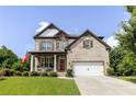 Charming two-story home featuring a covered porch with rocking chairs, brick and stone facade, and manicured lawn at 521 Andes Ln, Canton, GA 30114