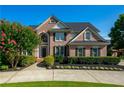 Two-story brick home featuring lush landscaping, a well-manicured lawn, and classic architectural details at 801 Windsor Rdg, Canton, GA 30115