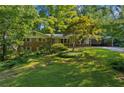 Charming single Gathering home with brick accents, a well-manicured lawn, and mature landscaping at 1646 Rainier Falls Ne Dr, Atlanta, GA 30329