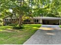Charming single Gathering home with brick accents, a well-manicured lawn, and a long driveway at 1646 Rainier Falls Ne Dr, Atlanta, GA 30329