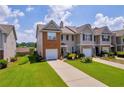 View of townhome with attached garage, landscaped yard, and inviting curb appeal at 176 Oak Green Dr, Lawrenceville, GA 30044