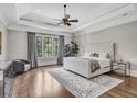 Serene bedroom features tray ceilings, a ceiling fan, hardwood floors, and a seating area with a large window at 4317 Oglethorpe Nw Loop, Acworth, GA 30101