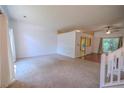 Spacious living room area with carpet flooring, white walls, and natural light from a large window at 7472 Woods Ct, Lithonia, GA 30058