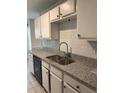 Kitchen sink with updated faucet, granite countertop, tile backsplash, and black dishwasher at 1120 Brandon Hill Way, Jonesboro, GA 30238
