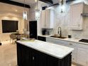 Modern kitchen with black and white cabinets, marble countertops, stainless steel appliances and pendant lighting at 4070 Runnnymede, Lilburn, GA 30047