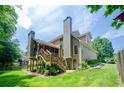 Back exterior of home featuring a screened in porch, a deck and lush green backyard at 4138 Glenlake Nw Ter, Kennesaw, GA 30144