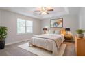 Serene main bedroom boasts a tray ceiling, plush carpet, and a calming, neutral color palette at 45 Kelsey Way, Palmetto, GA 30268