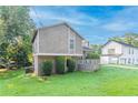 Side view of the property showing lush green lawn, mature trees, and a two-story home design at 8670 Brandon Hill Ln, Jonesboro, GA 30238