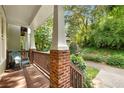 Relaxing covered porch with brick supports, wooden railings, and a comfortable chair at 106 Oakhurst Ter, Decatur, GA 30030