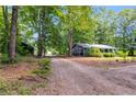 Exterior side view of a well-kept home with mature trees and a long driveway at 220 Gamble Dr, Carrollton, GA 30116