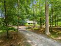 A charming home featuring a gravel drive surrounded by lush trees and foliage at 220 Gamble Dr, Carrollton, GA 30116