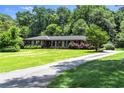 A single story brick home with a long, paved driveway winding through the verdant front yard at 2532 Millbrook Dr, Snellville, GA 30078