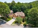 Aerial view of a brick home with mature trees surrounding the property in a lush, green neighborhood at 290 Edwardton Ct, Roswell, GA 30076