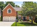 Charming brick home with a well-manicured lawn, mature tree, and a classic mailbox near a paved driveway at 290 Edwardton Ct, Roswell, GA 30076
