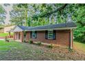 Side view of a classic brick ranch-style house, showcasing its clean lines, dark shutters and simple landscaping at 4748 Carson Sw Pass, Atlanta, GA 30331