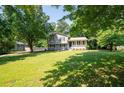 View of the two-story home surrounded by a lush green lawn and mature trees at 2880 Brett Nw Cir, Acworth, GA 30101