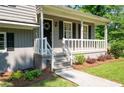 Inviting front porch with white railing, a wreath on the front door, and manicured landscaping at 2880 Brett Nw Cir, Acworth, GA 30101