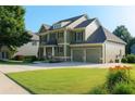 Inviting two-story home featuring a two-car garage and a lush green lawn at 730 Midway Ave, Canton, GA 30114