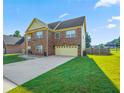 A charming two-story house with a well-maintained green lawn and a spacious driveway leading to the garage at 85 Shiver Blvd, Covington, GA 30016