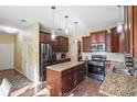 Stylish kitchen with dark wood cabinets, granite countertops, stainless steel appliances, and an island at 85 Shiver Blvd, Covington, GA 30016