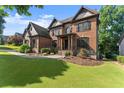 Stately brick home with lush green lawn and landscaped garden beds at 2539 Sagebrush Trl, Buford, GA 30519
