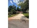 Exterior shot of a two-story home with a long driveway and mature trees at 504 Tracy Ct, Lawrenceville, GA 30046