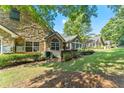 Lush backyard with stone and siding home exterior, showcasing landscaping and inviting outdoor space at 5228 Stone Village Circle Northwest #14 Nw Cir # 14, Kennesaw, GA 30152