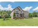 Beautiful two-story brick home featuring a manicured lawn, mature landscaping, and a welcoming entrance at 1405 Rainey Way, Hampton, GA 30228