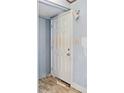Entry door from inside with peeling paint on the wall and damaged floor at 4235 Apache Se Dr, Acworth, GA 30102