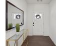 Inviting entryway with dark wood floors, a large mirror, stylish console table, and a view of the front door at 5534 Radford Loop, Fairburn, GA 30213