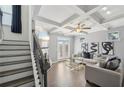 Elegant living room with coffered ceilings, a fireplace, stylish furnishings, and a staircase visible on the left at 5534 Radford Loop, Fairburn, GA 30213