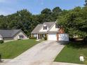 Inviting home featuring a well-kept lawn, spacious driveway, and traditional architectural details at 964 Natural Brook Trl, Lawrenceville, GA 30045