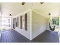 Cozy covered porch with a hanging hammock chair and dark wood flooring, great for relaxing at 20 Scarlett Oak Ne Dr, Cartersville, GA 30121