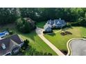 Expansive property featuring a blue-sided home, a long driveway, and a beautiful manicured lawn and garden at 200 Chaparral Trce, Tyrone, GA 30290
